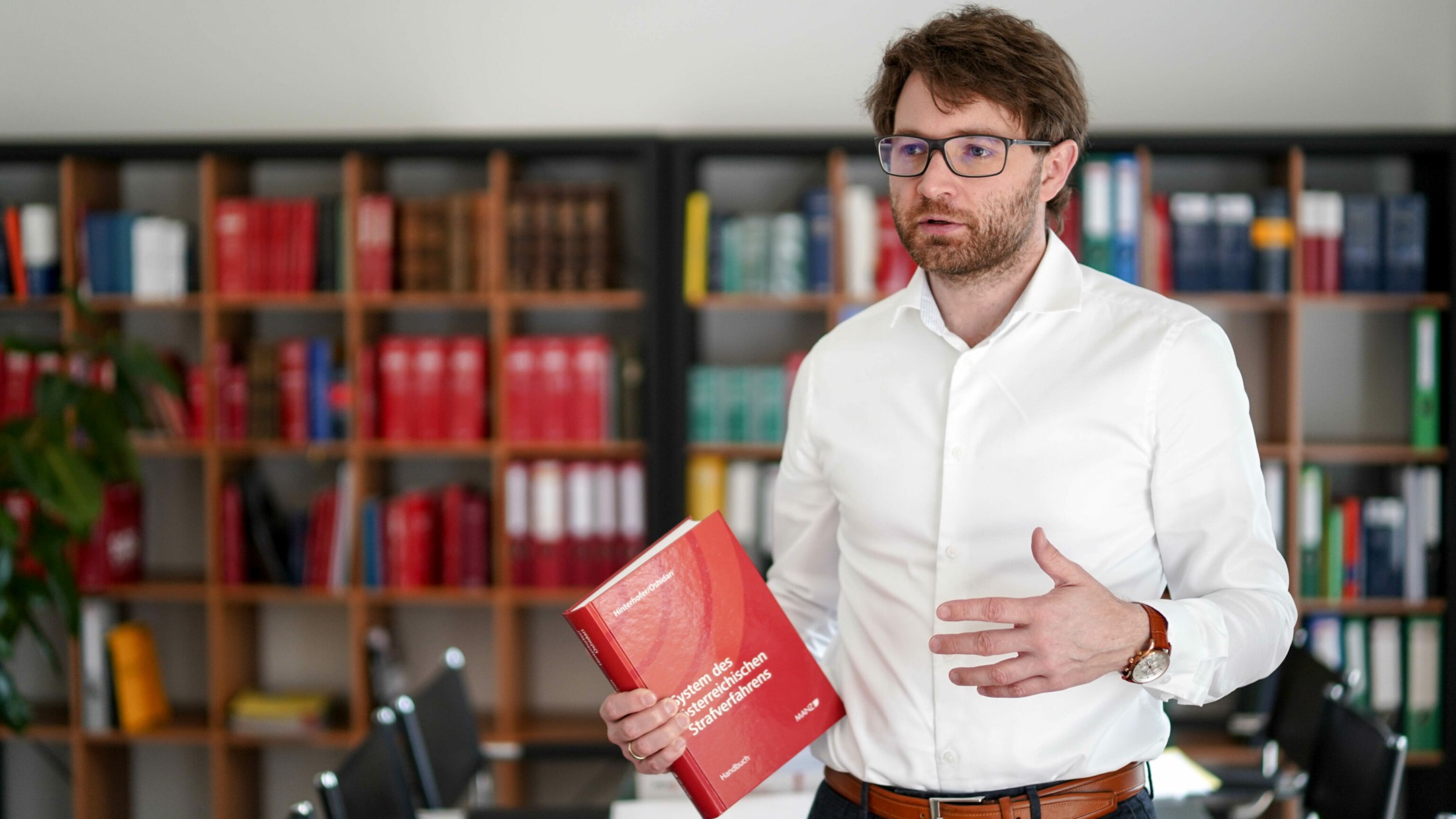 Lorenz Kirschner als Experte für Erbrecht mit Buch vor Bücherregal